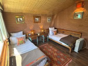 a bedroom with two beds and a table with a desk at MeenaBagh Villa Rooms & Cafe in Shimla