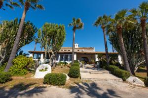 a house with palm trees in front of it at Kite Hostel Stagnone in Marsala
