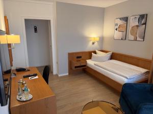 a small hotel room with a bed and a table at Hotel Hansa in Herford +40 photos