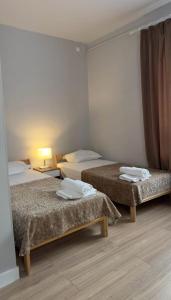 a room with three beds and a lamp at SAFIA Hotel in Pavlodar