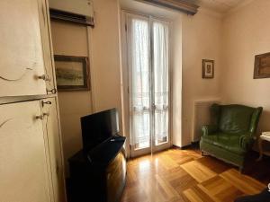 a living room with a green chair and a television at Suite in Private Villa in Milan