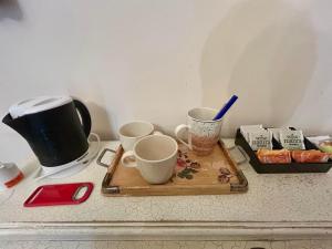 a counter with three cups and a tray of food at Suite in Private Villa in Milan