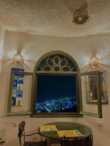 a room with a table and a window with a view at Haven Hills Chaouen in Chefchaouen