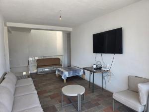 a living room with a couch and a flat screen tv at Casa Horizonte Azul Acapulco in Acapulco