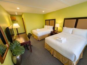 a hotel room with two beds and a desk at Grand Persepolis Inn in Niagara Falls