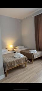 a hotel room with two beds and a lamp at SAFIA Hotel in Pavlodar