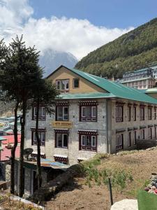 a building with a tree in front of it at Hotel Sheryang in Namche