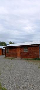 a large wooden barn with a white roof at cabaña zoila ch in Coñaripe