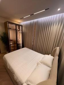 a bedroom with a bed and a window with curtains at luxury rooftop apartment in Jeddah