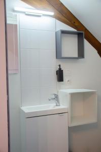 a white bathroom with a sink and a mirror at Le Relais de Jeanne in Orbigny