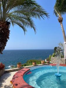 a swimming pool with the ocean in the background at Habitacion Mar in Puerto Escondido