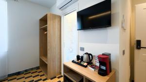 a room with a tv on the wall and a table at BORGO MARE 86 rooms in Porto SantʼElpidio