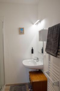 a white bathroom with a sink and a shower at Le Relais de Louis in Orbigny