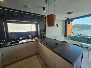 a kitchen with a sink and a large window at Rakoczówka in Znamirowice