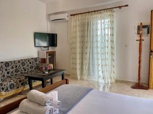 a room with a bed and a couch and a television at VIOLA Seaside Villa in Ksamil