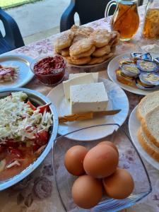 a table with plates of food and eggs and bread at Villa Karolina in Ohrid