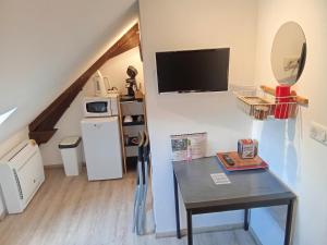 a small room with a table and a tv at Le Relais de Louis in Orbigny