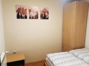 a bedroom with three pictures on the wall at PLANINSKI KUTAK Tara - Apartman 1 in Bajina Bašta