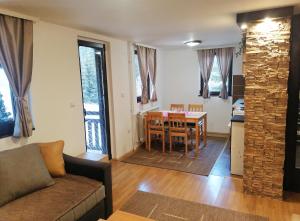 a living room with a couch and a table and a kitchen at PLANINSKI KUTAK Tara - Apartman 1 in Bajina Bašta