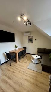 a living room with a table and a couch at Pokoje nad Jeziorem Solina in Solina
