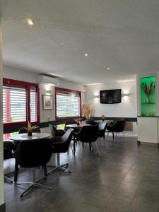 a dining room with tables and chairs and a flat screen tv at Hotel City Inn in Magdeburg +42 photos
