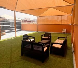 a group of chairs and tables on a roof at luxury rooftop apartment in Jeddah