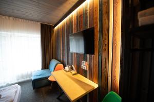 a hotel room with a table and a tv on a wall at Loft & SPA resort ROOMs in Palyanytsya