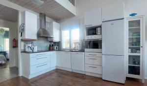 a white kitchen with white cabinets and appliances at Levin Lumienkeli A6 in Levi