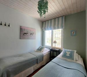 a bedroom with two beds and a window at Levin Lumienkeli A6 in Levi