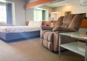 a living room with a couch and a bed at Monument Inn & Suites in Gering