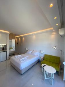 a bedroom with a large bed and a green couch at Panoramic View Boutique Suite in Rethymno