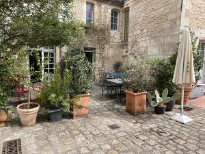 a patio with a bunch of plants and an umbrella at Le Bon Appart in Angoulême