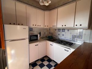 a kitchen with white cabinets and a refrigerator at cerronegro con terraza in Capileira