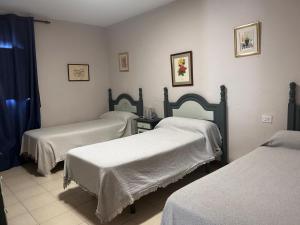 a hospital room with two beds with white sheets at cerronegro con terraza in Capileira