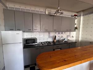a kitchen with a white refrigerator and a wooden table at cerronegro con terraza in Capileira +3 photos