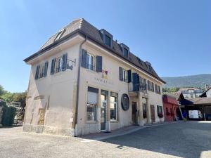 ein großes weißes Gebäude an einer Straßenseite in der Unterkunft HostHelp - Les Balises in Bevaix + 8 Fotos