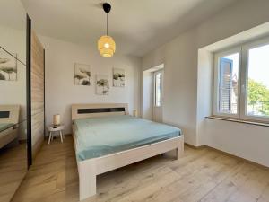 ein Schlafzimmer mit einem Bett und zwei Fenstern in der Unterkunft HostHelp - Les Balises in Bevaix