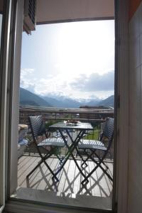 a table and chairs on a balcony with a view at Casa Verena in Aosta