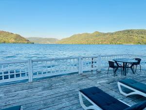 a wooden deck with tables and chairs on the water at NOAH ponton in Orşova