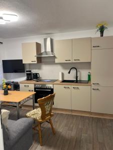 a kitchen with white cabinets and a table and a couch at Bergblick in Saupsdorf
