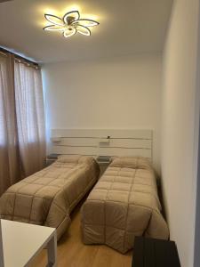 two beds in a bedroom with a ceiling fan at Hotel 31 in Limena