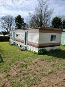 a mobile home is parked in a yard at Family friendly static in Pwllheli
