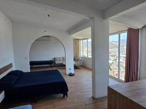 a bedroom with a blue bed and a living room at Casa Horizonte Azul Acapulco in Acapulco +46 photos