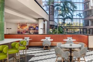 a restaurant with tables and chairs in a building at The Westshore Grand, Tampa, A Tribute Portfolio Hotel in Tampa +55 photos