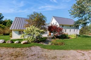 a white house with a gray roof at Hike, Bike, & Explore: Vermont Family Farmhouse! in New Haven
