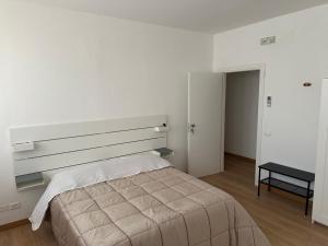 a white bedroom with a large bed and a desk at Hotel 31 in Limena