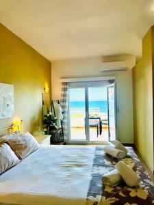 a bedroom with a bed with a view of the beach at Nautica Hotel Apartments in Stavromenos +117 photos