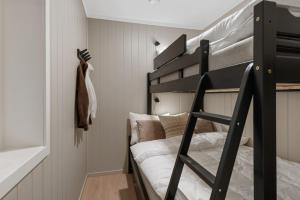 a bedroom with a bunk bed with a black bunk ladder at Motoppen, Høgeggvegen 4B in Trysil