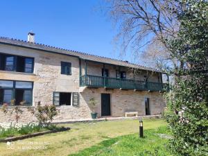 an old stone building with a green balcony on it at Casa Quinta de Cecil in Villalba