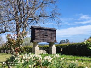 a bird house in a garden with flowers at Casa Quinta de Cecil in Villalba